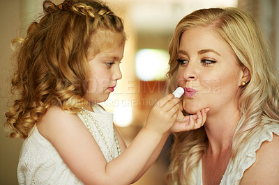 Buy stock photo Cropped shot of a little girl applying lipstick to her mother at home