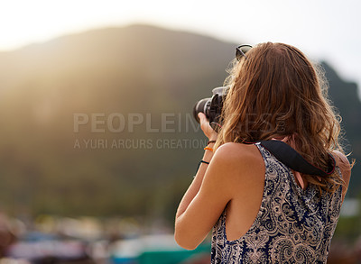 Buy stock photo Cropped shot of a young woman taking photos with her camera at the beach