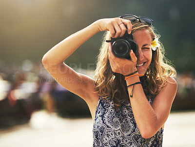 Buy stock photo Portrait of a young woman taking photos with her camera at the beach