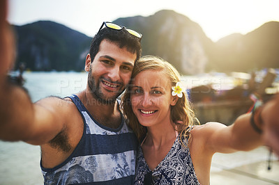 Buy stock photo Portrait of a young couple taking a selfie at the beach