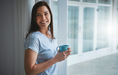 Buy stock photo Cropped shot of an attractive young woman enjoying a coffee by her patio door