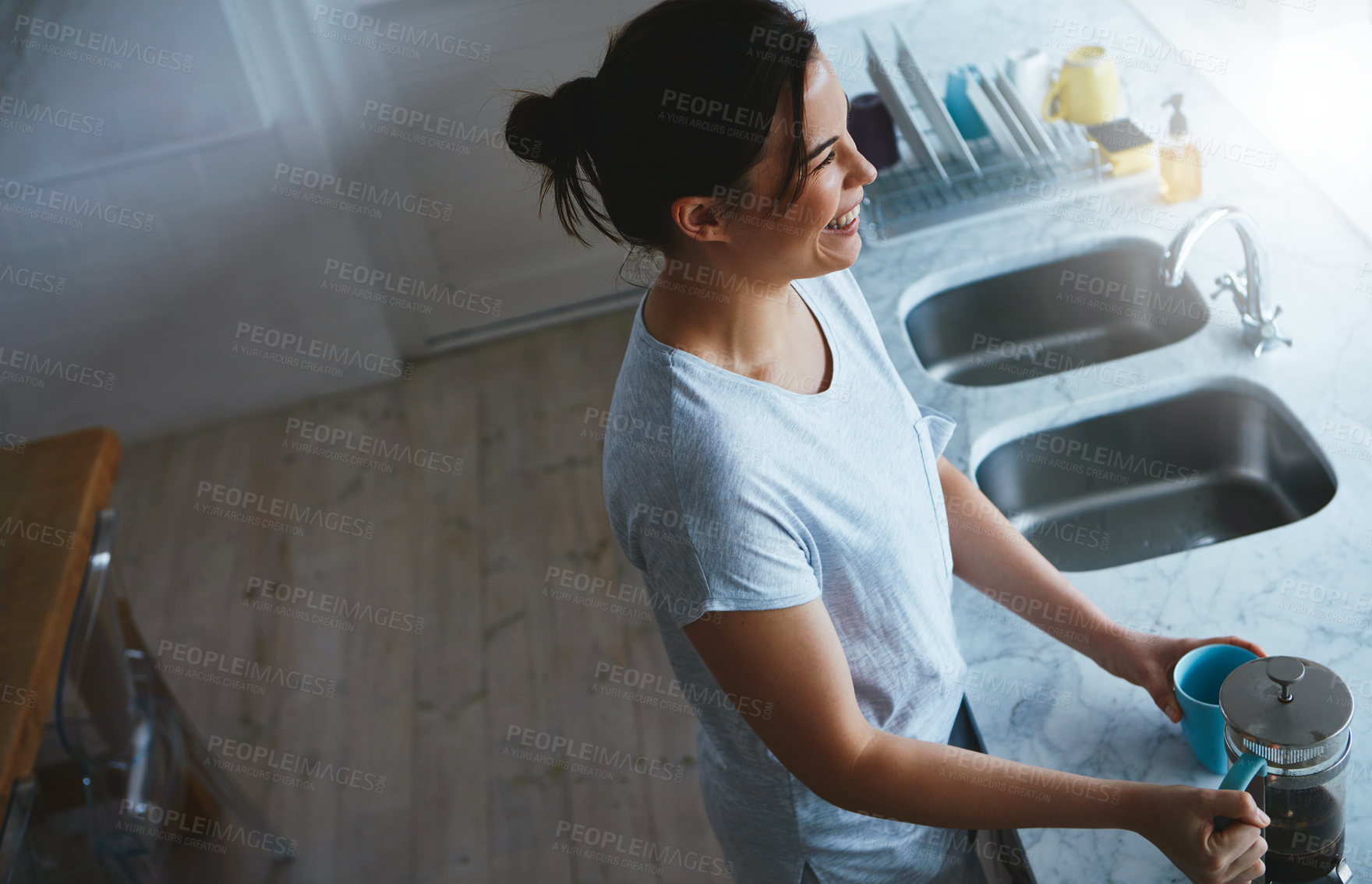 Buy stock photo High angle shot of an attractive young woman preparing a pot of coffee in the kitchen