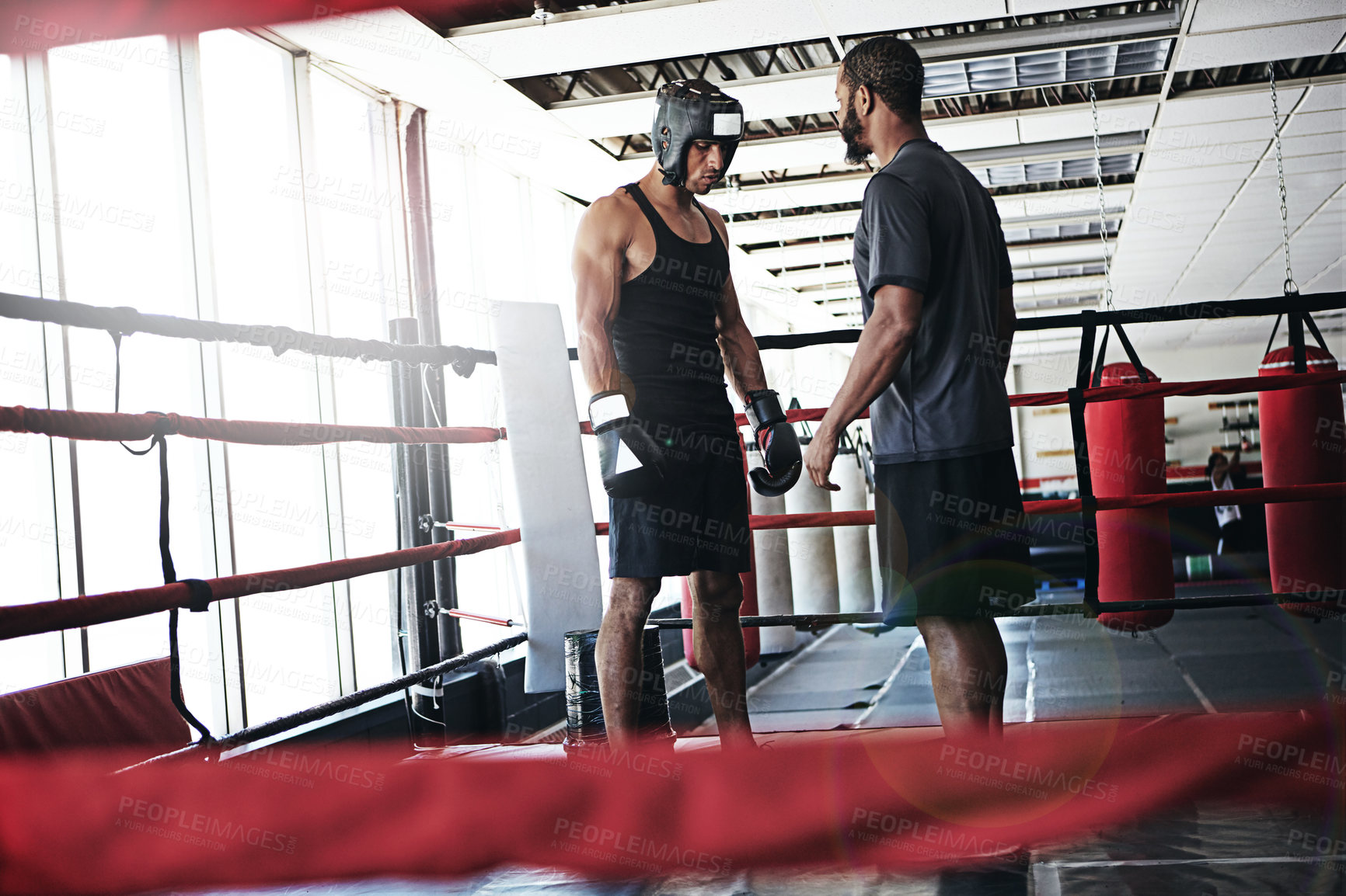 Buy stock photo Shot of a man training in the boxing ring with a coach