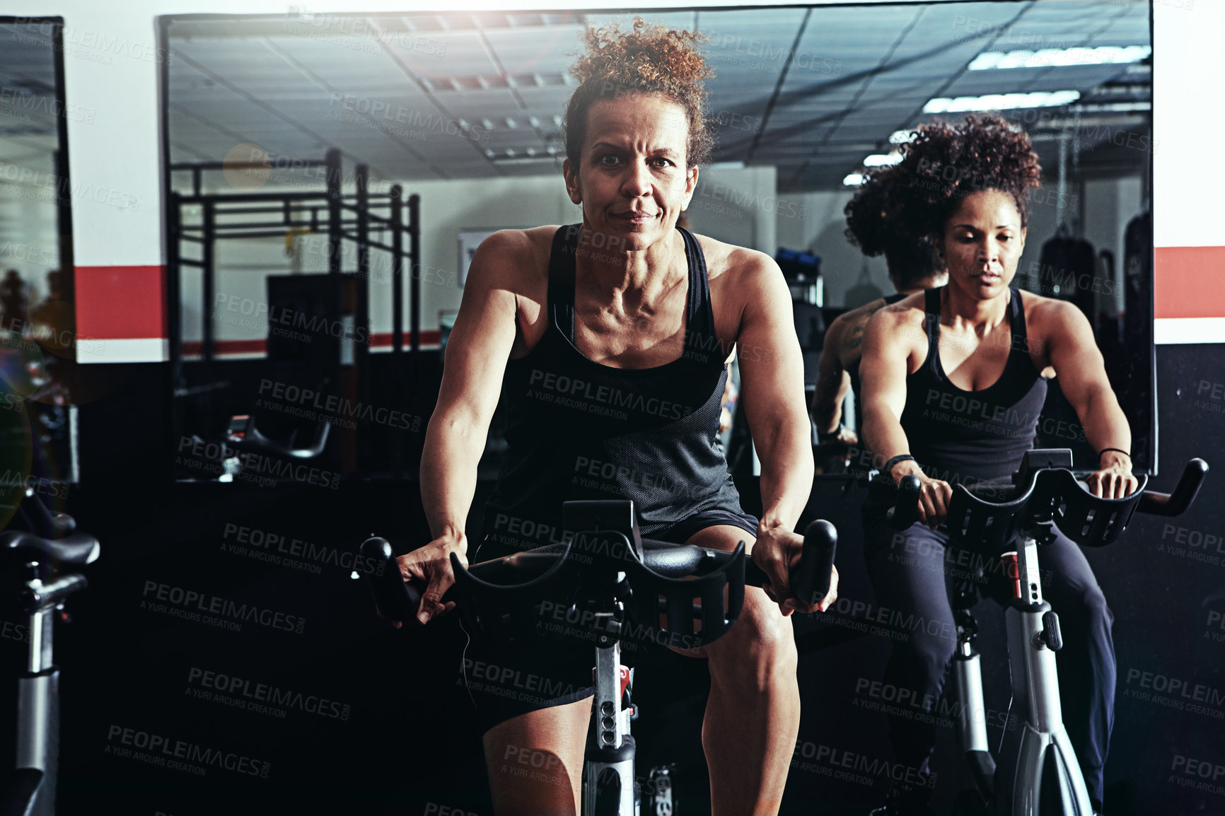 Buy stock photo Exercise bike, challenge and women in gym, fitness or high energy with endurance, progress or cycling. People, performance or girls with training, cardio or body workout with hobby, sports or support