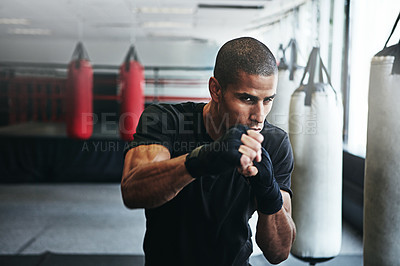 Buy stock photo Fight, punching and man in gym for exercise, boxing challenge or competition training. Power, muscle and champion boxer at workout with confidence, fitness and energy in MMA sports club with gloves.