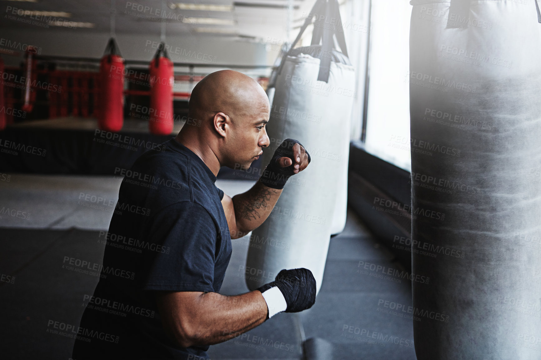 Buy stock photo Fitness, punching bag and man in MMA gym for boxing, challenge or competition training. Power, muscle and serious champion boxer at workout with confidence, fight and energy in sports exercise club.