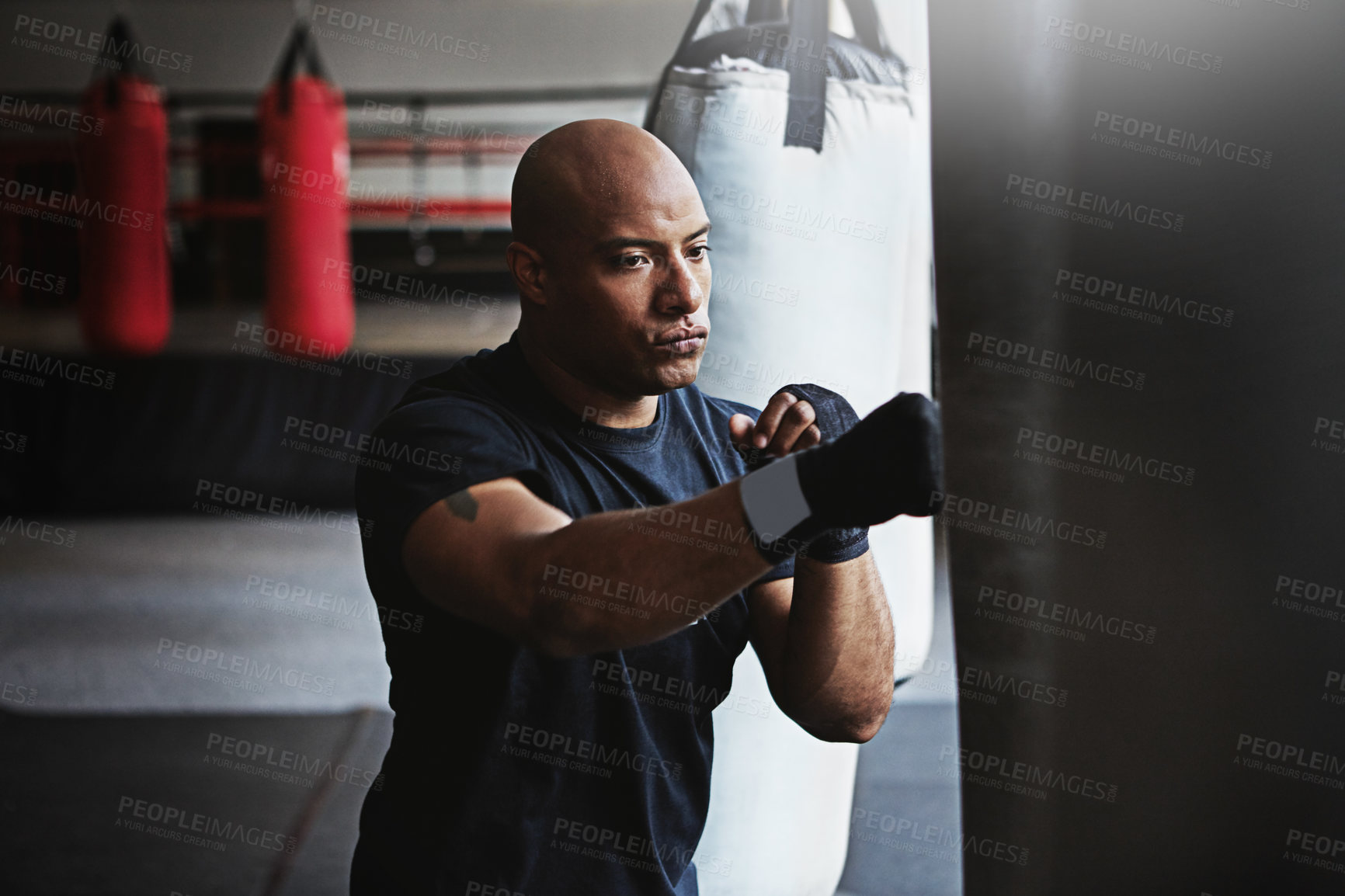 Buy stock photo Fitness, punching bag and man in MMA challenge for boxing, gym or competition training. Power, muscle and serious champion boxer at workout with confidence, fight and energy in sports exercise club.