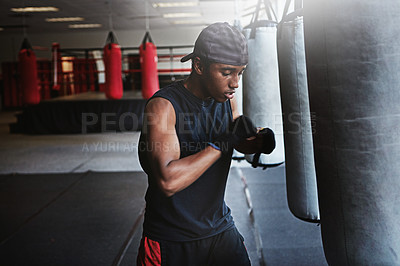 Buy stock photo Fitness, punching bag and black man in boxing gym for MMA, challenge or competition training. Power, muscle and champion boxer at workout with confidence, fight and energy in sports exercise club.