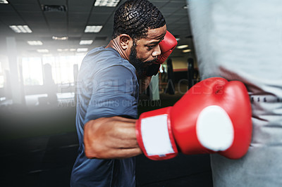 Buy stock photo Shot of a male boxer training at the gym