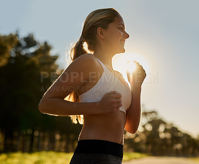 Buy stock photo Shot of a happy young woman out for a run in nature