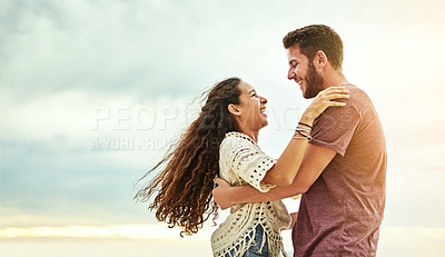 Buy stock photo Cropped shot of an affectionate young couple enjoying their time on the beach