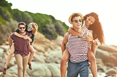 Buy stock photo Cropped shot of two affectionate young couples enjoying their time on the beach
