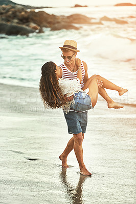 Buy stock photo Full length shot of an affectionate young couple enjoying their time on the beach