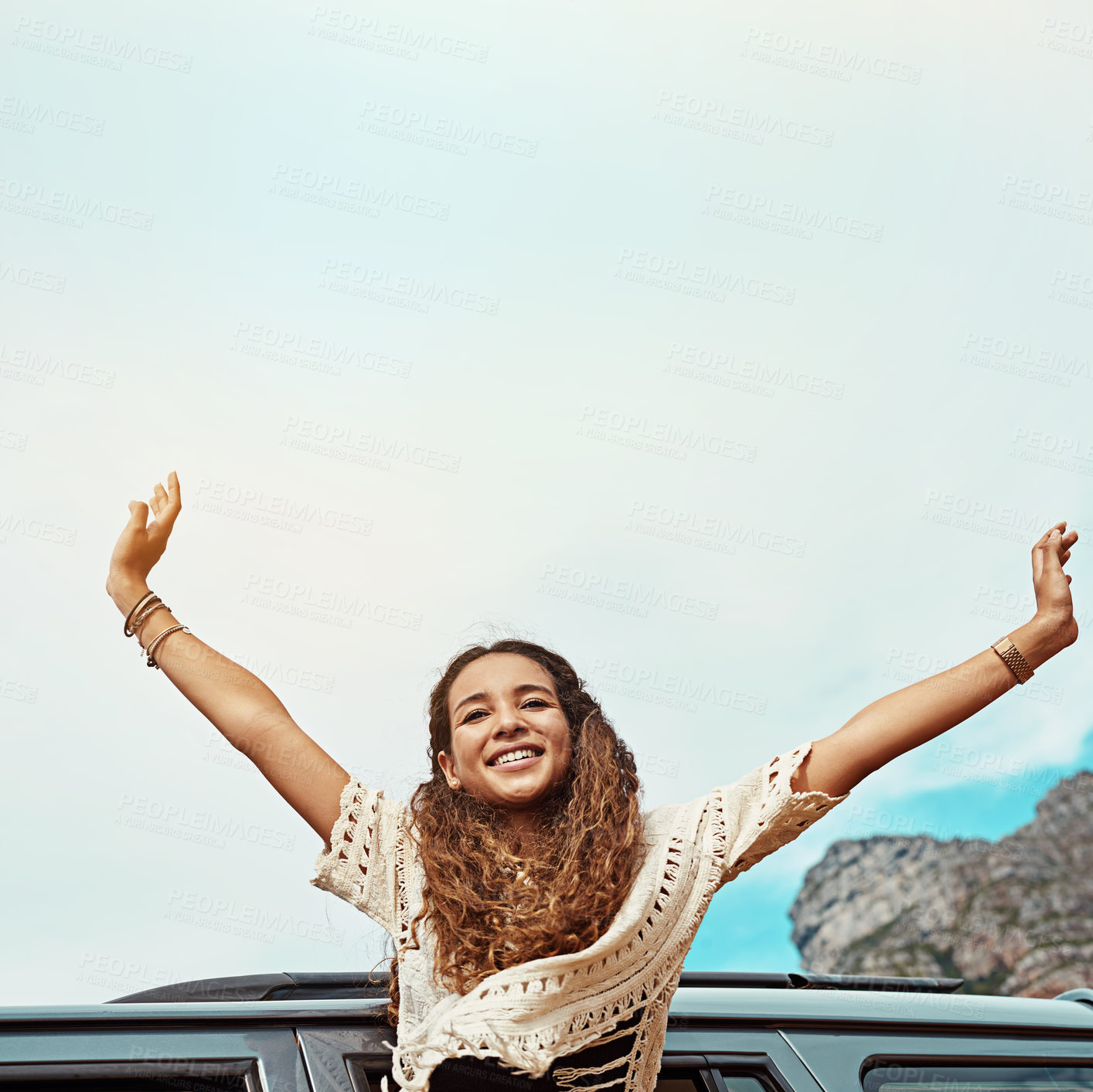 Buy stock photo Cropped shot of a young woman leaning out a car with her arms outstretched while on a roadtrip