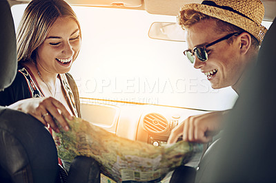 Buy stock photo Cropped shot of a young couple reading a map while on a roadtrip together