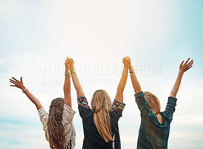 Buy stock photo Rear view shot of a group of friends standing with their arms outstretched outside