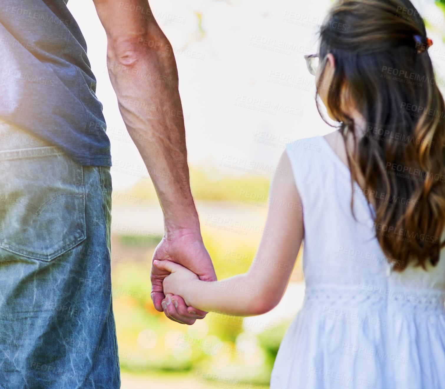 Buy stock photo Rear view shot of a little girl holding her father's hand outside