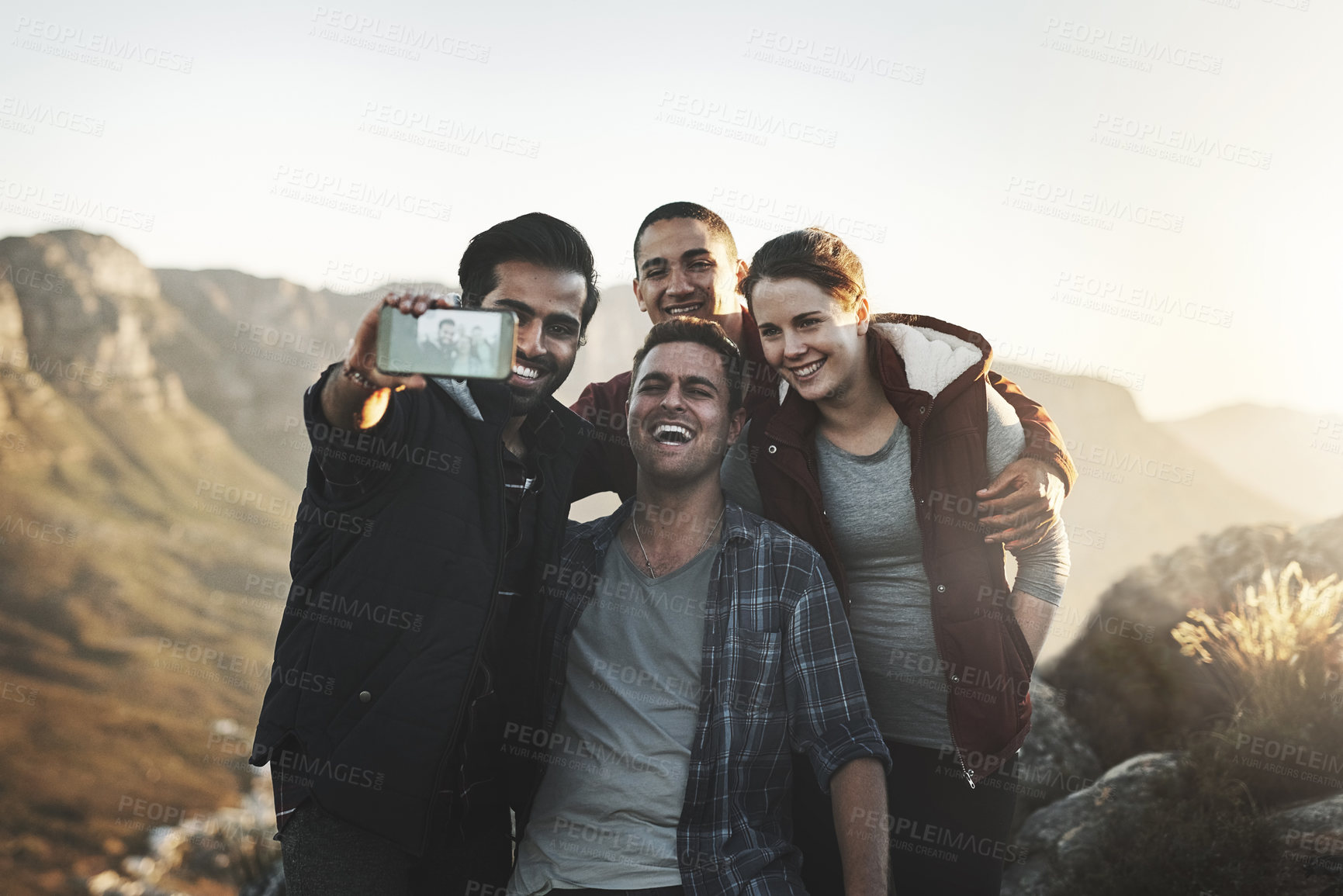 Buy stock photo Shot of a group of friends taking selfies while hiking together in the mountains