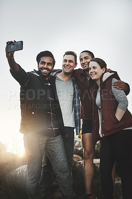 Buy stock photo Shot of a group of friends taking selfies while hiking together in the mountains