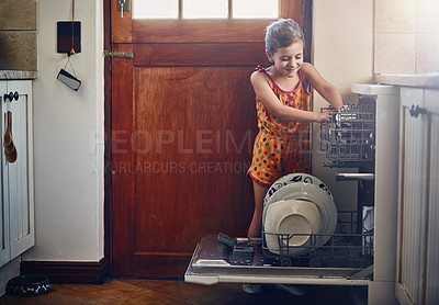 Buy stock photo Shot of a little girl using a dishwashing machine at home