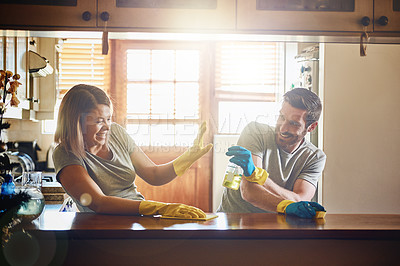 Buy stock photo Cropped shot of a young couple having fun while doing chores together at home