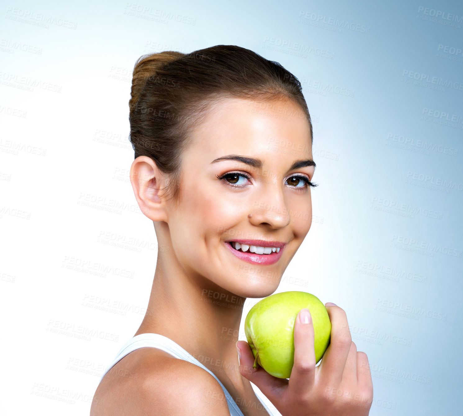 Buy stock photo Portrait of a health-conscious young woman posing with an apple in studio