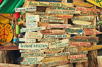 Buy stock photo Shot of a sign in a bar showing the distance to various travel destinations