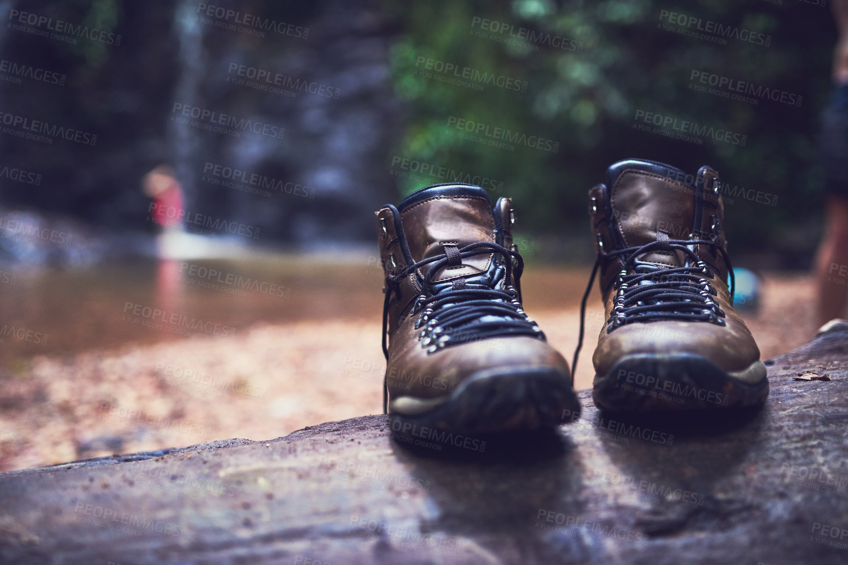 Buy stock photo Shot of a pair of empty shoes standing on a log by a river in a jungle