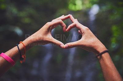 Buy stock photo Shot of an unidentifiable young woman making a heart gesture with her hands in the jungle