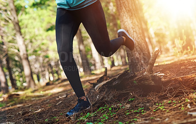 Buy stock photo Cropped shot of an unrecognizable young woman out for a jog in the woods