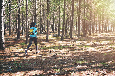 Buy stock photo Full length shot of an athletic young woman out for a jog in the woods