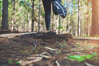 Buy stock photo Cropped shot of an unrecognizable young woman out for a jog in the woods