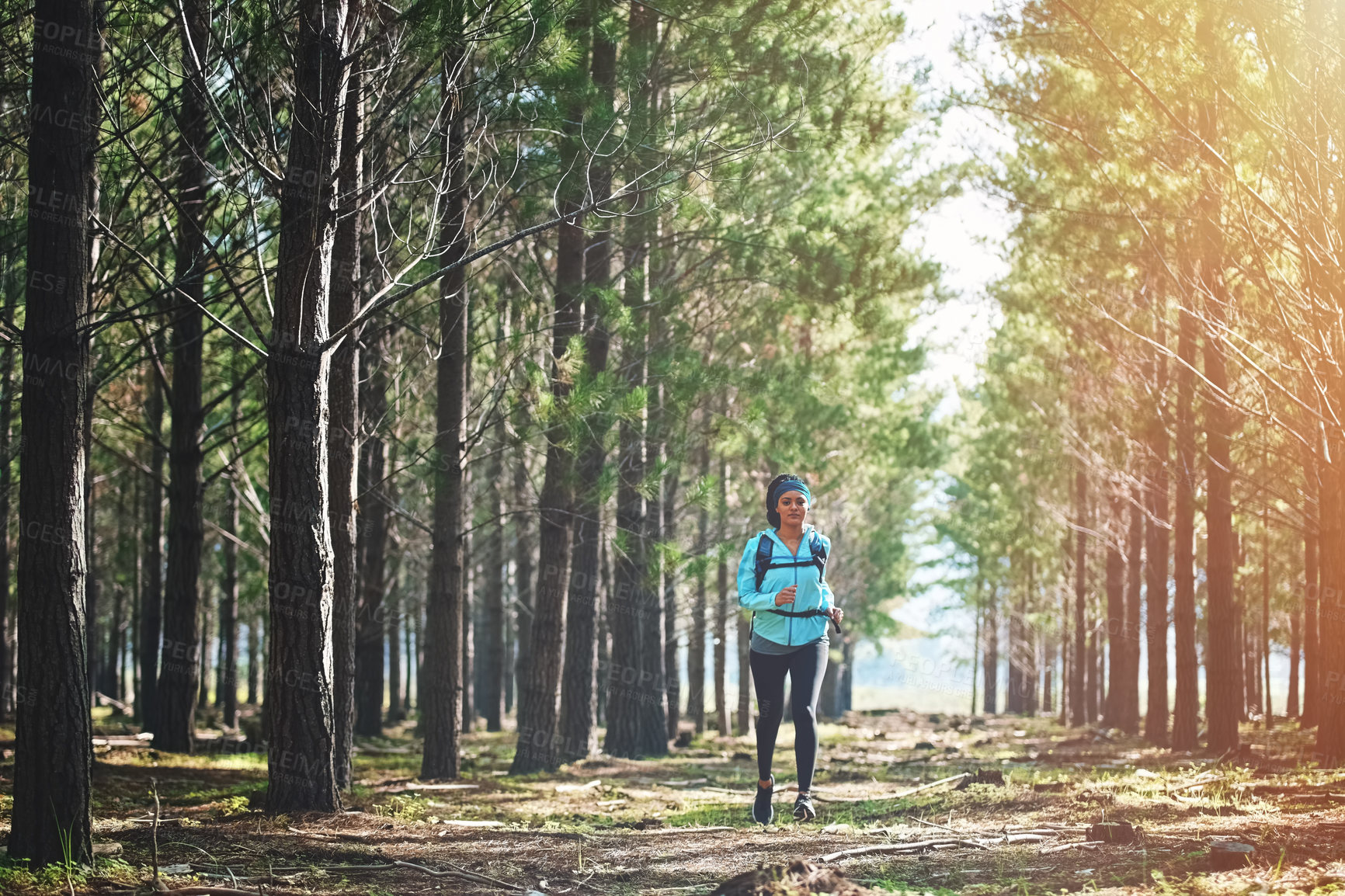 Buy stock photo Full length portrait of an athletic young woman out for a jog in the woods