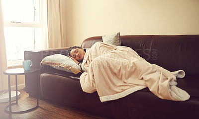 Buy stock photo Shot of a young woman sleeping on her living room sofa