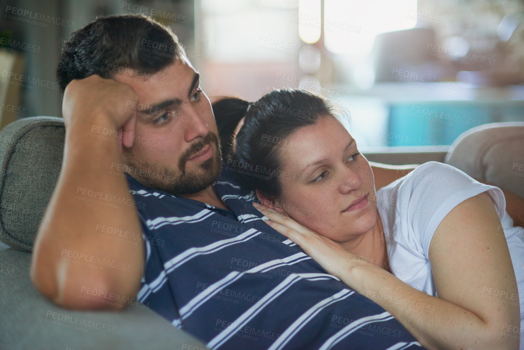 Buy stock photo Shot of a loving pregnant couple relaxing on the couch together at home