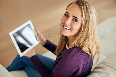 Buy stock photo High angle portrait of an attractive young woman using her tablet at home