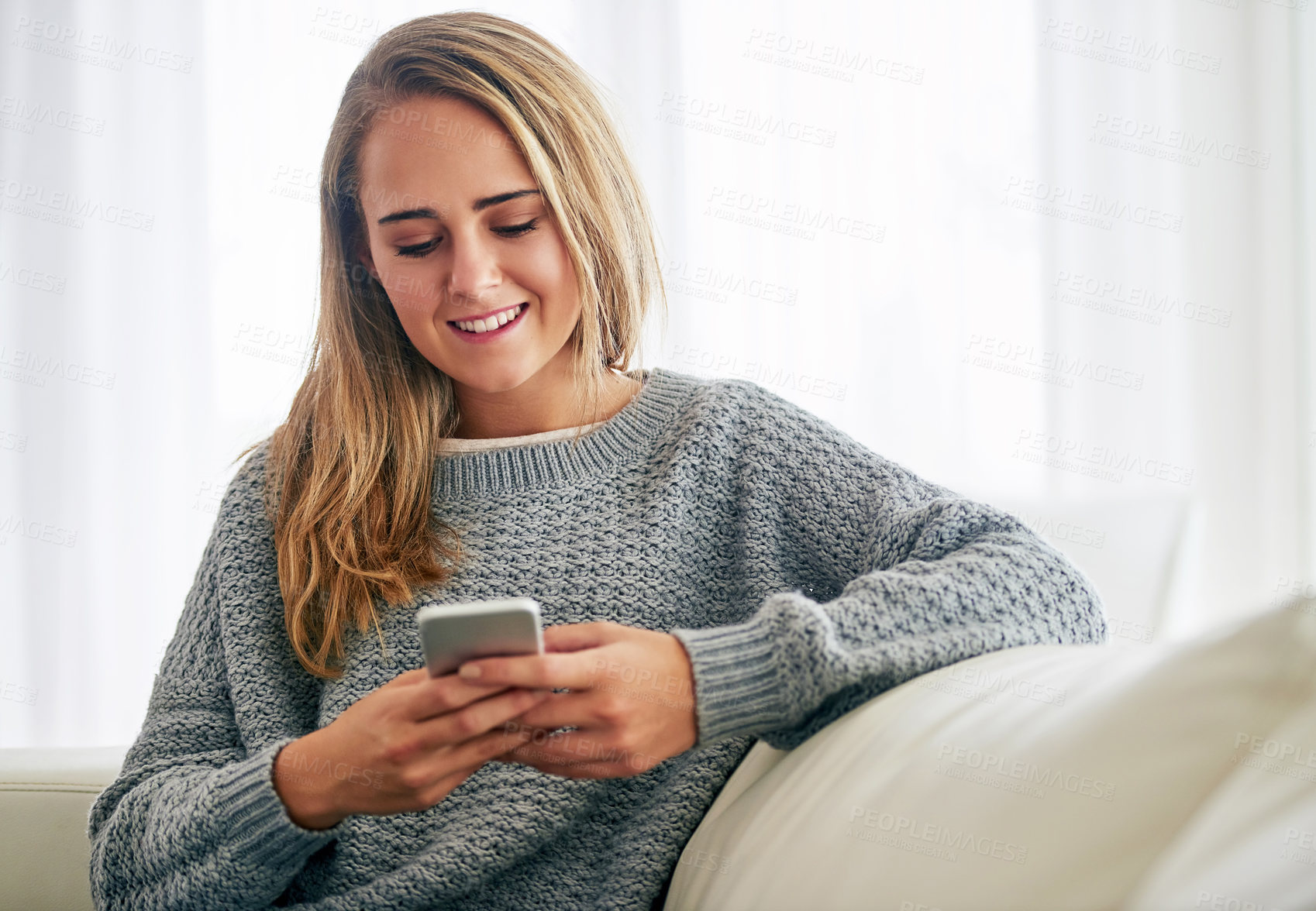 Buy stock photo Woman, home and relaxing on couch with smartphone for social media, online post and watch videos for fun. Girl, sofa and smile or laugh in lounge for entertainment, streaming service and website