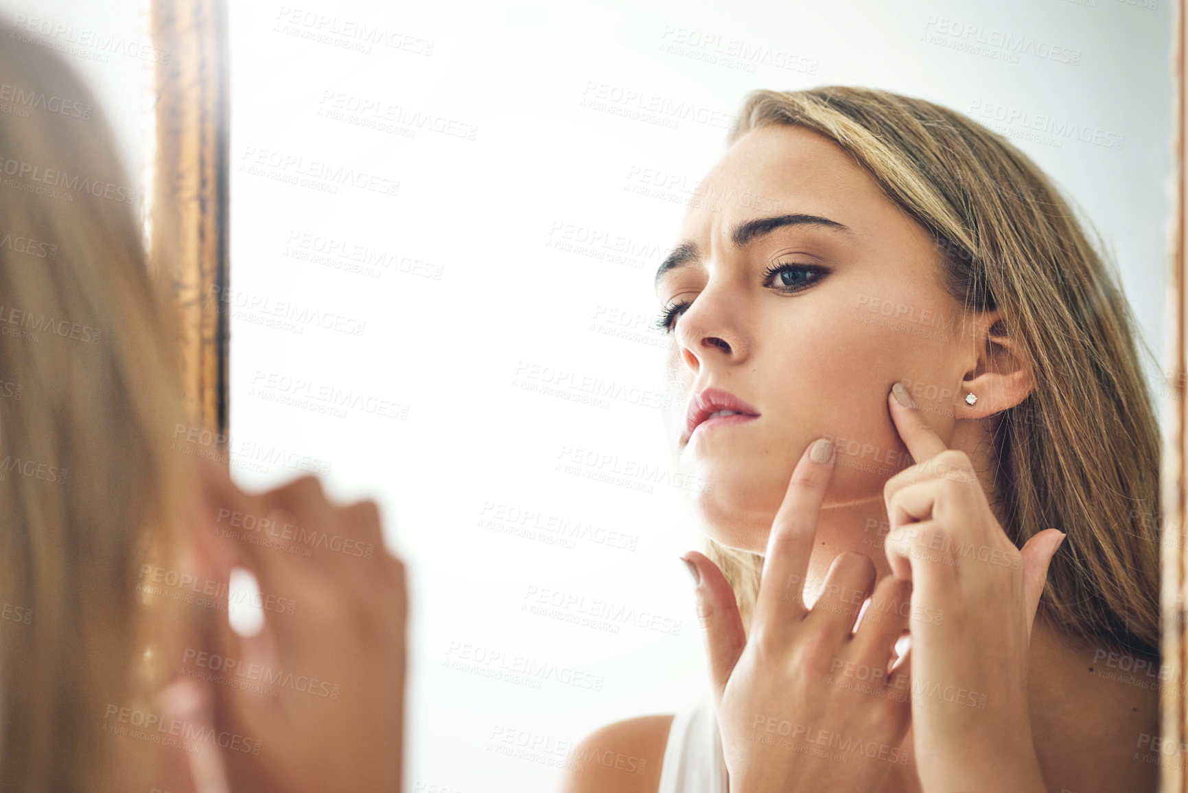 Buy stock photo Cropped shot of an attractive young woman popping a pimple