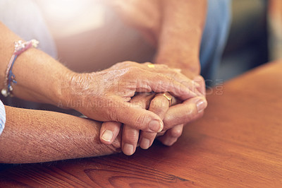 Buy stock photo Cropped shot of a senior man and woman holding hands in comfort