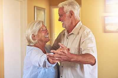 Buy stock photo Shot of a happy senior couple dancing together at home