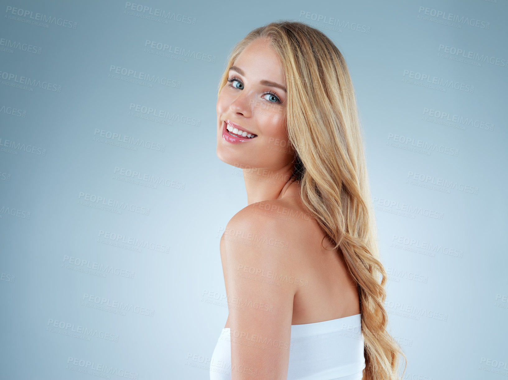 Buy stock photo Studio portrait of a beautiful young blonde woman posing against a blue background