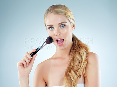 Buy stock photo Surprise, woman and portrait with makeup brush in studio for cosmetic, beauty and foundation of aesthetic. Female person, wow and salon tools for glamour, transformation and glow on blue background