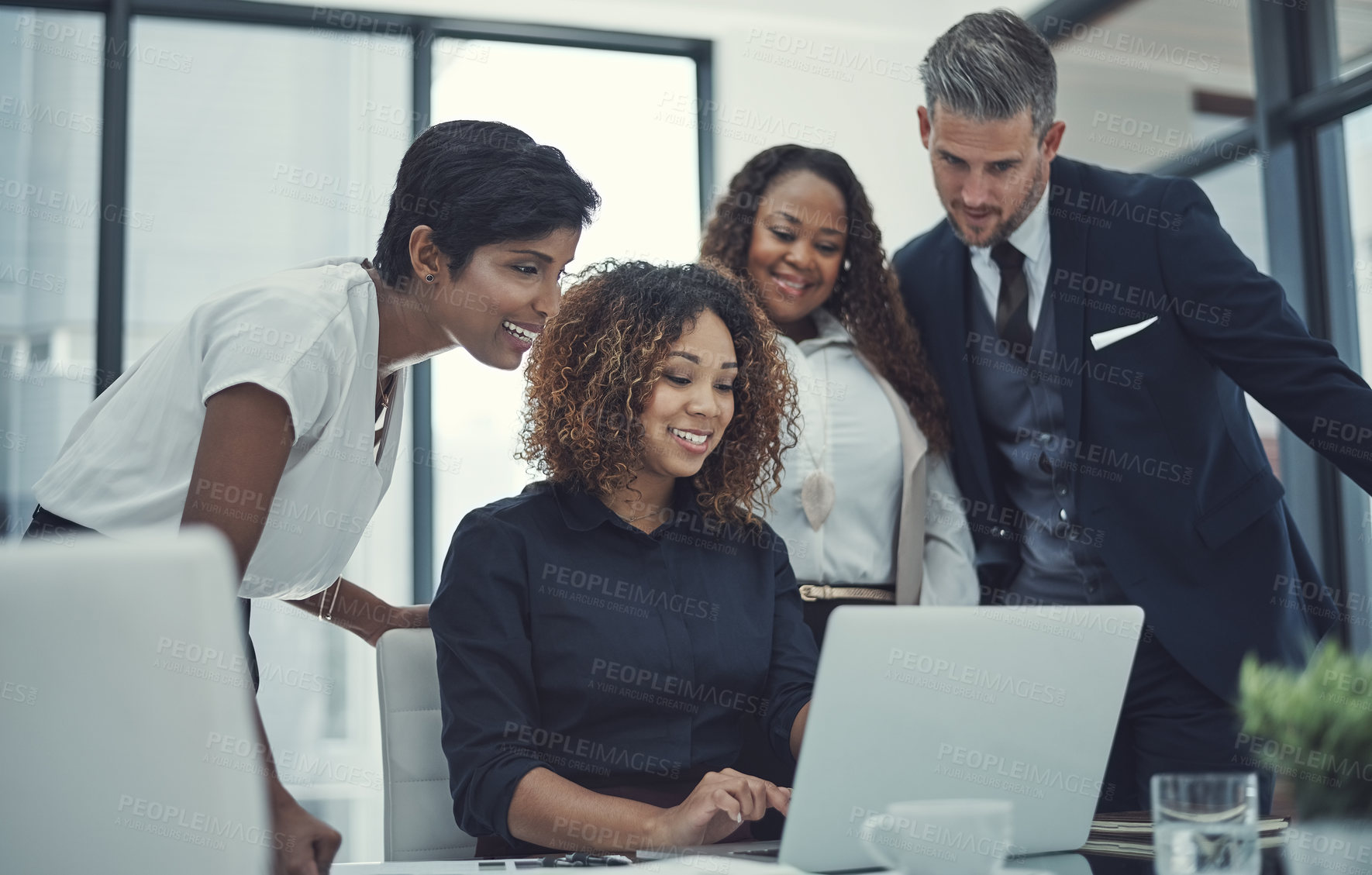 Buy stock photo Shot of a group of colleagues using a laptop together in a modern office