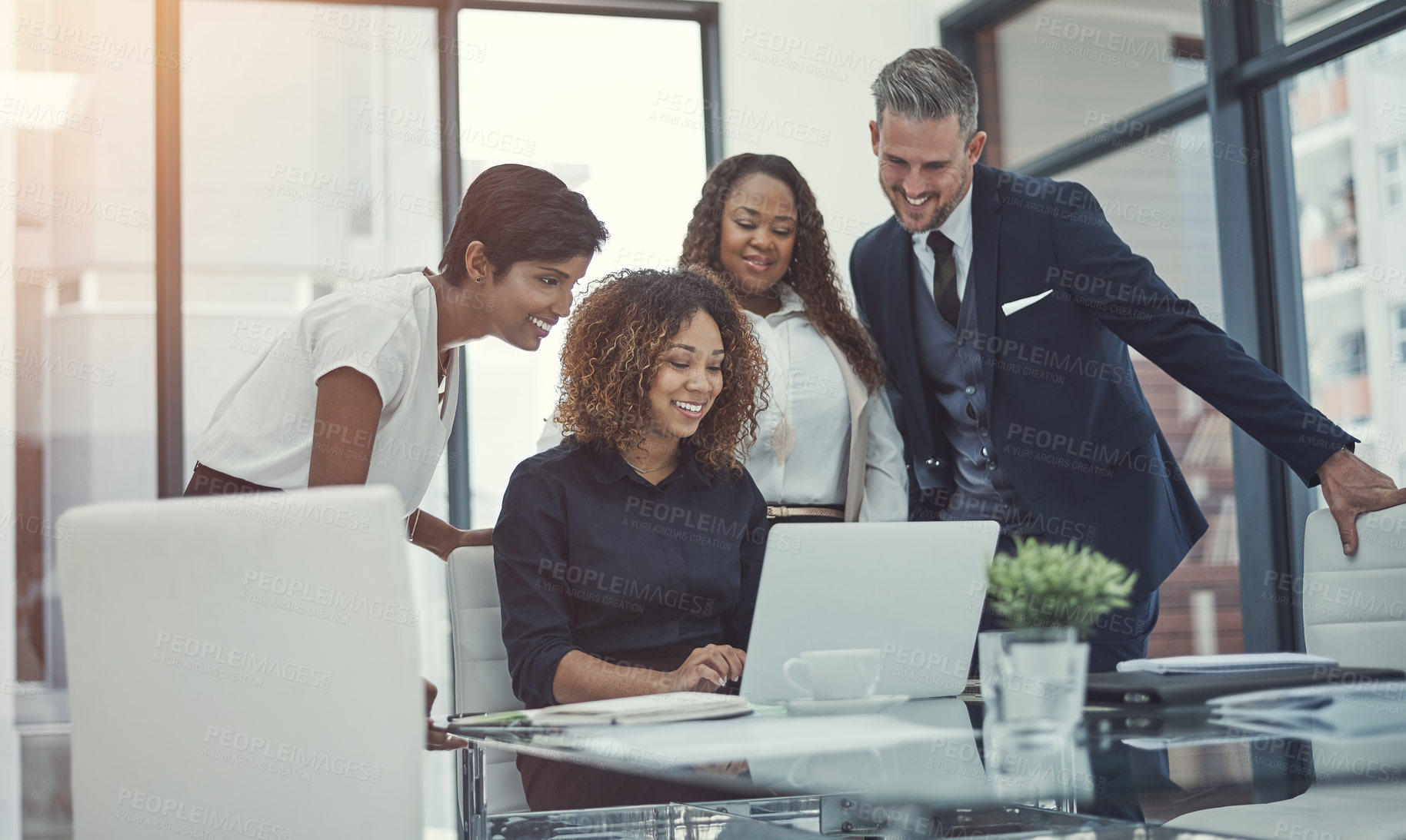 Buy stock photo Shot of a group of colleagues using a laptop together in a modern office