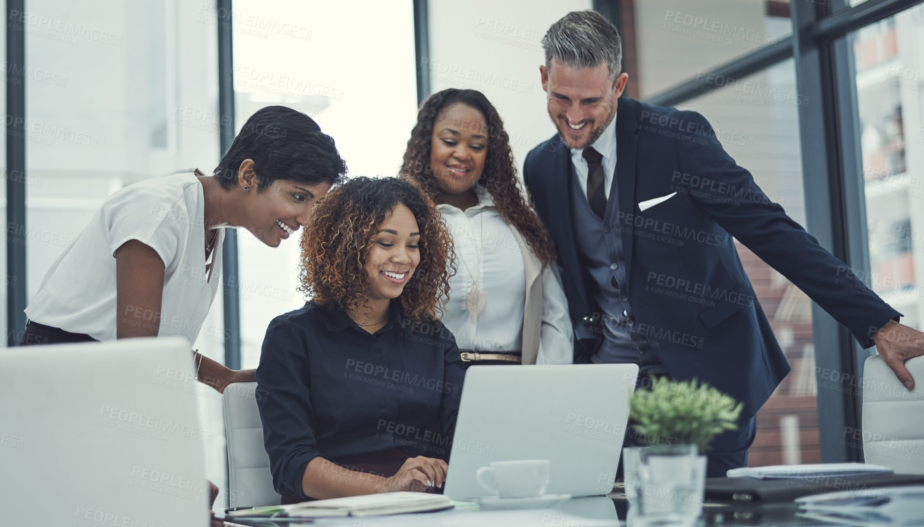 Buy stock photo Shot of a group of colleagues using a laptop together in a modern office