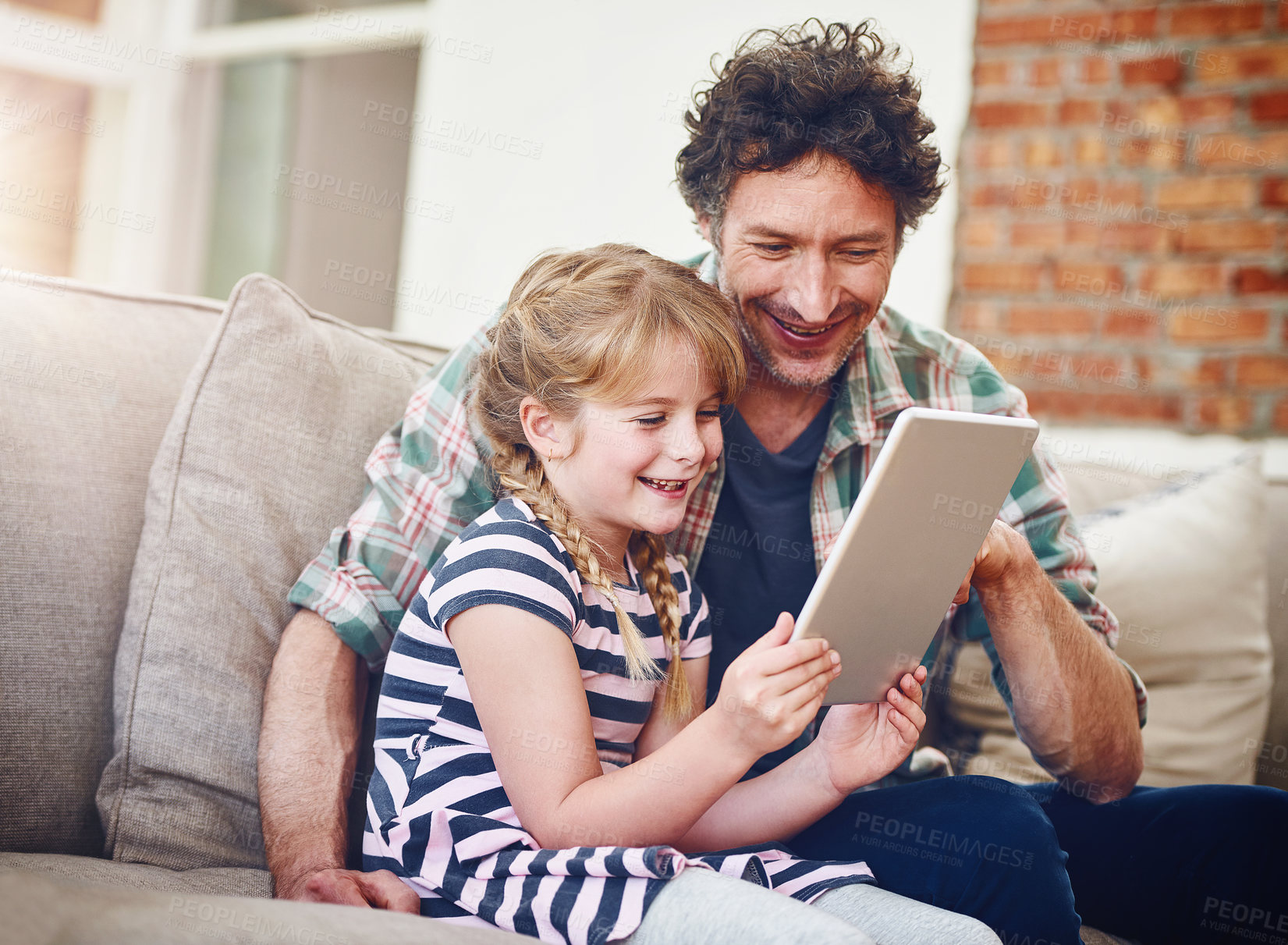 Buy stock photo Happy, dad and girl with tablet in sofa at home for elearning, child development and knowledge with growth. Parent, kid and support with help, teaching and educational games for entertainment