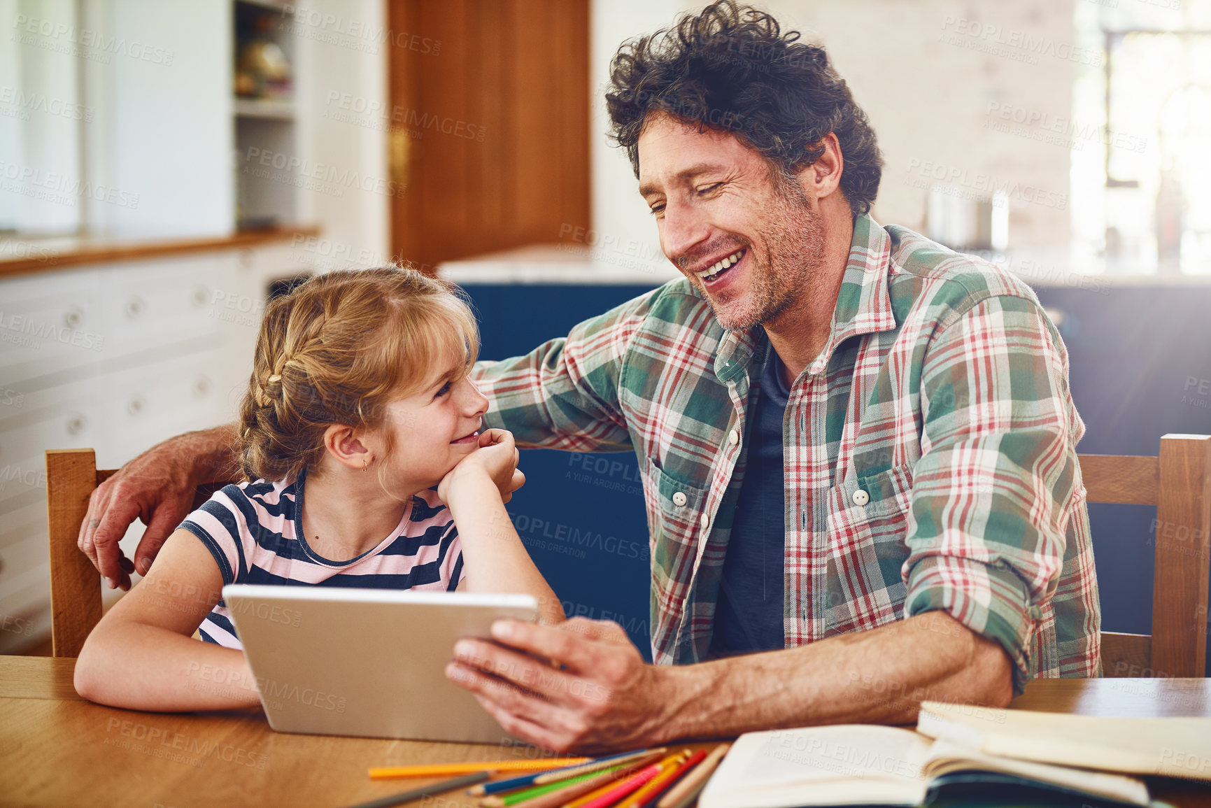 Buy stock photo Cropped shot of a father helping his daughter complete her homework on a digital tablet
