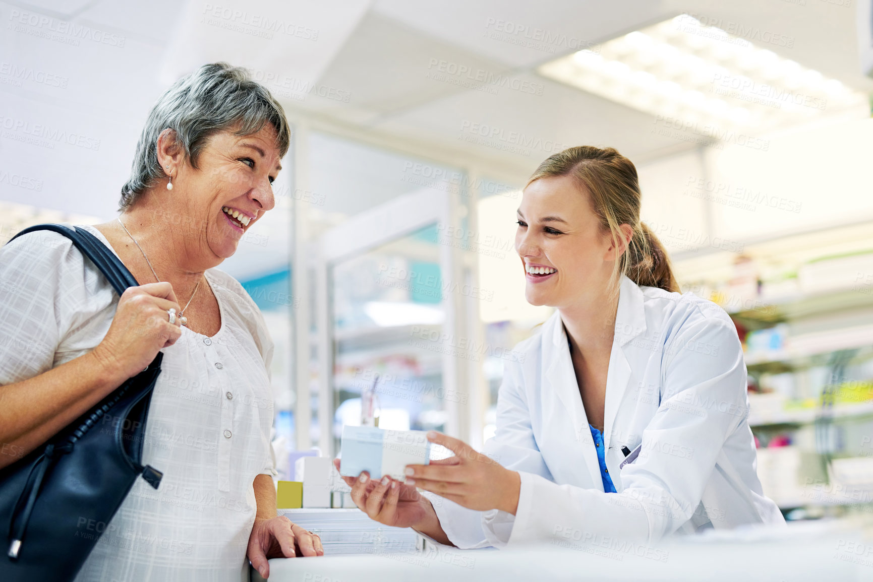 Buy stock photo Shot of a young pharmacist assisting a customer