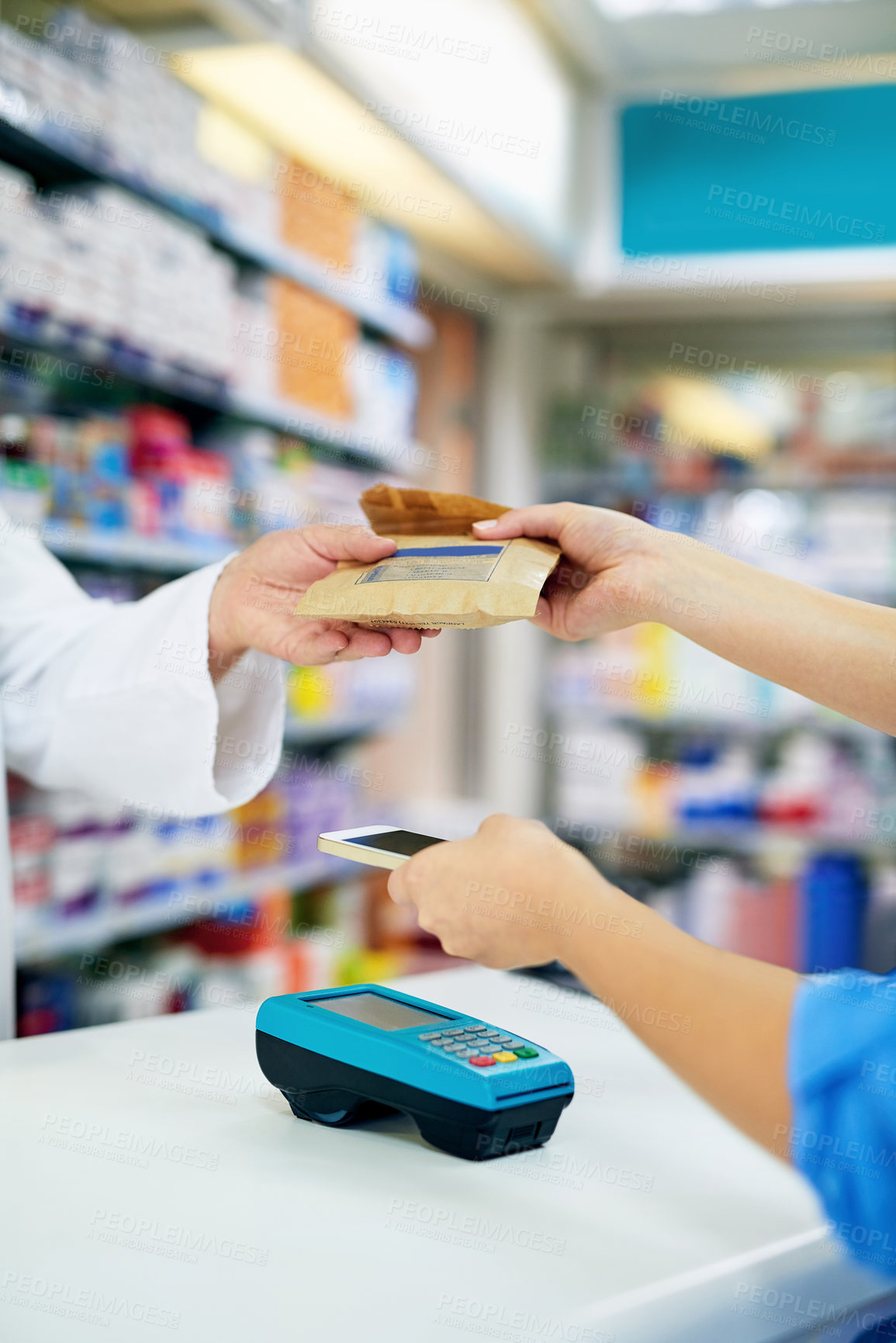 Buy stock photo Cropped shot of a customer paying for merchandise with her smartphone at a pharmacy