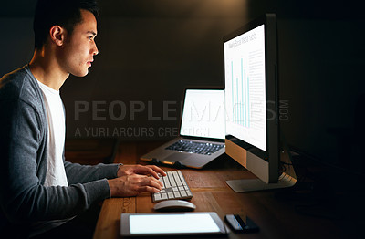 Buy stock photo Shot of a handsome young male programmer working late in his office